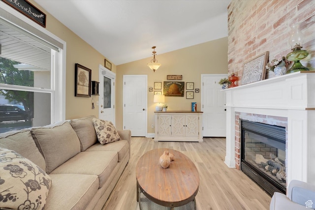 42 E Frontier Ct, Saratoga Springs, UT 84045 - living room with light wood finished floors, lofted ceiling, and a brick fireplace