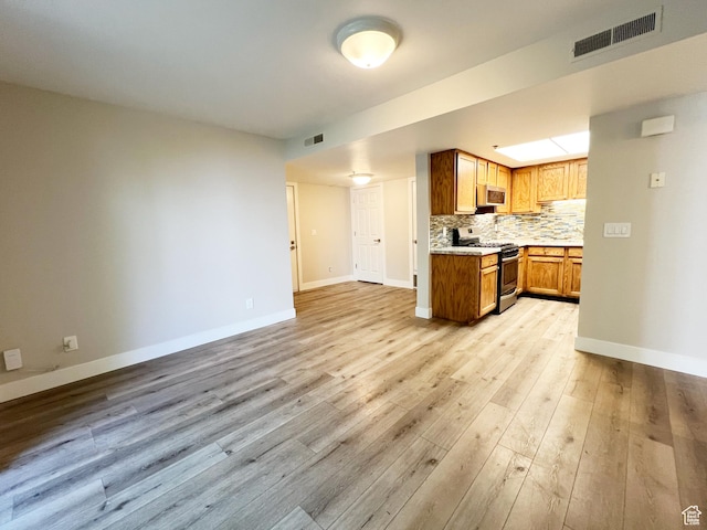 543 S 900 E Unit C3, Salt Lake City, UT 84102 - kitchen featuring appliances with stainless steel finishes, open floor plan, baseboards, light wood finished floors, and light countertops
