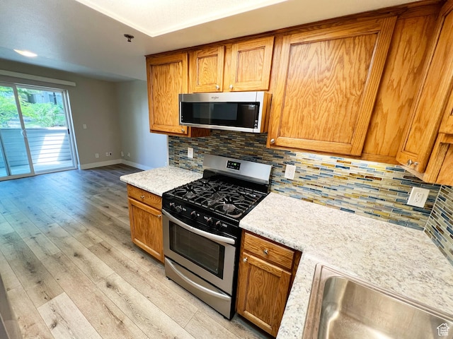 543 S 900 E Unit C3, Salt Lake City, UT 84102 - kitchen with appliances with stainless steel finishes, a sink, light wood finished floors, and light countertops