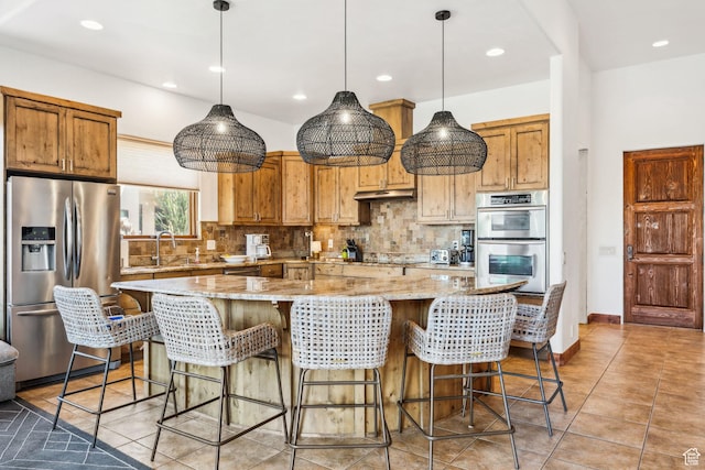 2090 N Tuweap Dr Unit 9, St George, UT 84770 - kitchen featuring stainless steel appliances, under cabinet range hood, backsplash, a spacious island, and recessed lighting