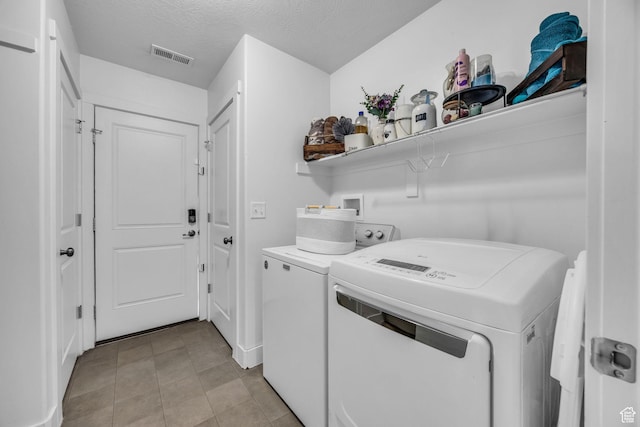 161 E 27th St S, Ogden, UT 84401 - laundry area featuring washer and dryer, light tile patterned floors, and a textured ceiling