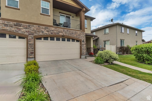 287 W 680 N, Centerville, UT 84014 - view of property featuring stone siding, stucco siding, a garage, a balcony, and driveway