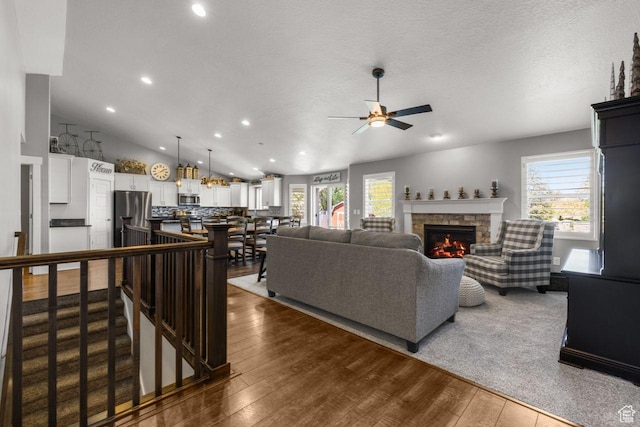 3498 W Harvestwood Ln S, Riverton, UT 84065 - living room featuring a ceiling fan, dark wood-style floors, a fireplace, recessed lighting, and lofted ceiling