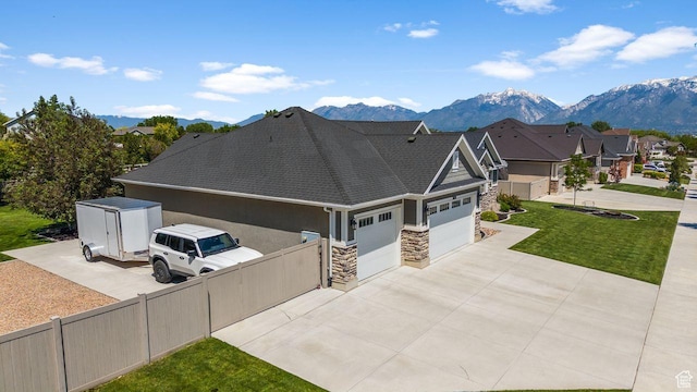 3498 W Harvestwood Ln S, Riverton, UT 84065 - view of front facade featuring stone siding, an attached garage, a mountain view, driveway, and a residential view