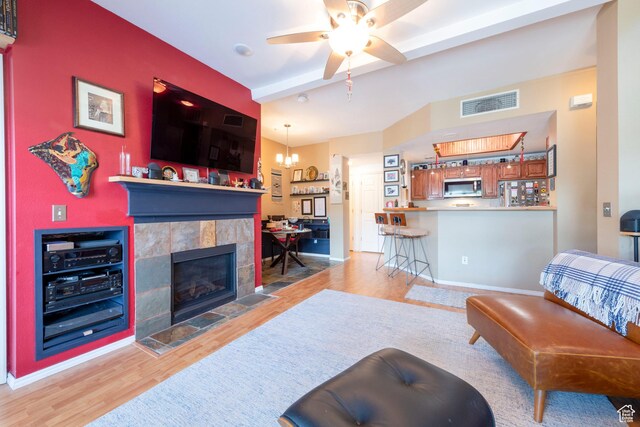 900 Bitner Rd Unit B37, Park City, UT 84098 - living area featuring wood finished floors, ceiling fan, a tiled fireplace, a chandelier, and baseboards