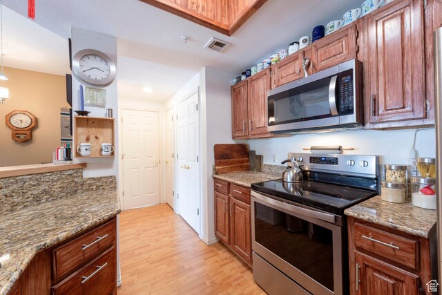 900 Bitner Rd Unit B37, Park City, UT 84098 - kitchen with appliances with stainless steel finishes, light wood-style floors, light stone countertops, brown cabinets, and recessed lighting