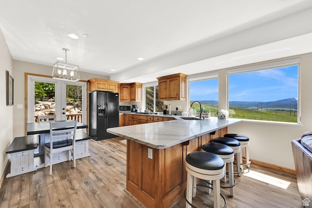5063 E Lakeview Dr Unit 1001, Eden, UT 84310 - kitchen with black fridge with ice dispenser, a sink, a peninsula, stainless steel microwave, and light wood-style flooring