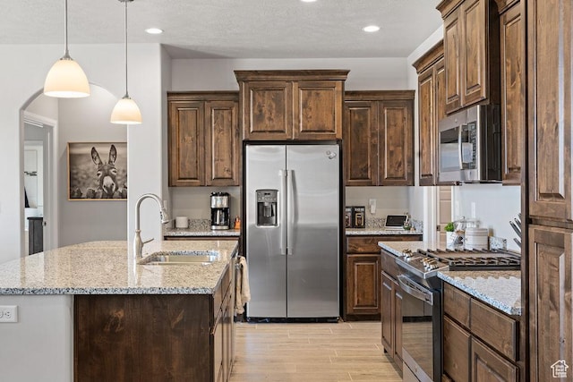 2738 W 270 N, Hurricane, UT 84737 - kitchen with stainless steel appliances, a sink, light wood finished floors, light stone countertops, and dark brown cabinets