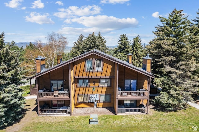 2025 Canyons Resort Dr Unit B7, Park City, UT 84098 - rear view of property featuring a chimney, a yard, and a balcony