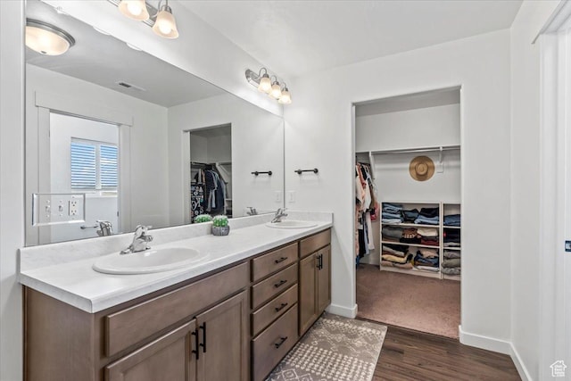 742 E Stonebriar Dr, Eagle Mountain, UT 84005 - bathroom featuring double vanity, a walk in closet, wood finished floors, and baseboards