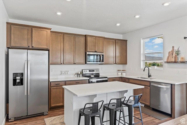 742 E Stonebriar Dr, Eagle Mountain, UT 84005 - kitchen featuring stainless steel appliances, a sink, wood finished floors, a breakfast bar, and recessed lighting