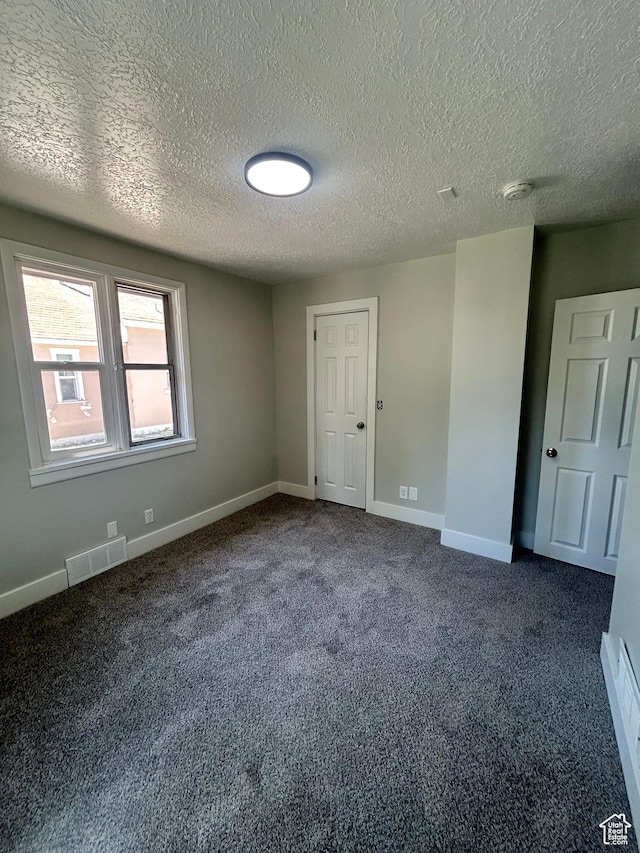 3042 Adams Ave, Ogden, UT 84403 - unfurnished bedroom with a textured ceiling, dark colored carpet, and baseboards