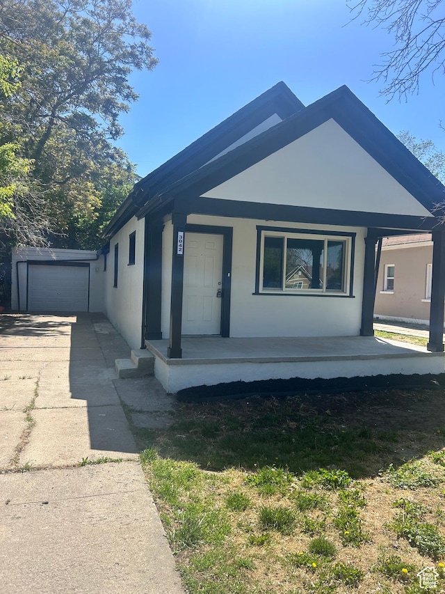 3042 Adams Ave, Ogden, UT 84403 - view of front of property featuring concrete driveway, a porch, a garage, and stucco siding