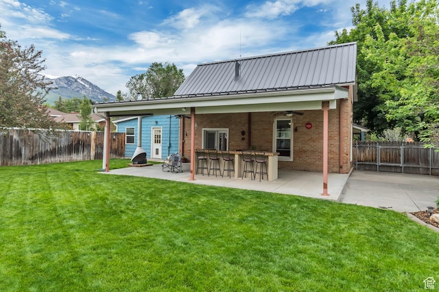 233 N Main St, Alpine, UT 84004 - rear view of house with a patio, brick siding, a mountain view, a ceiling fan, and metal roof