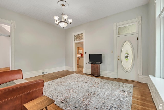 233 N Main St, Alpine, UT 84004 - unfurnished living room featuring a chandelier, wood finished floors, and baseboards