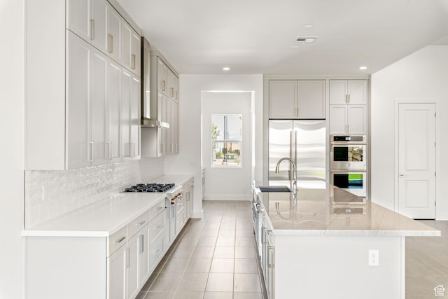 705 W Emerald Point Dr, St George, UT 84790 - kitchen featuring stainless steel appliances, a sink, baseboards, tasteful backsplash, and an island with sink