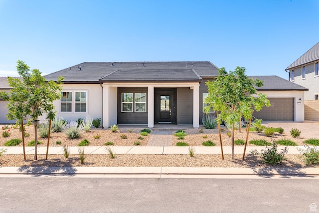 705 W Emerald Point Dr, St George, UT 84790 - view of front facade featuring covered porch, driveway, an attached garage, a tile roof, and stucco siding