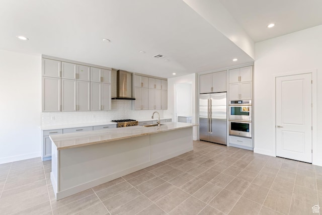 705 W Emerald Point Dr, St George, UT 84790 - kitchen with wall chimney range hood, stainless steel appliances, backsplash, a center island with sink, and a sink