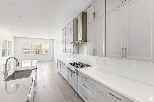 705 W Emerald Point Dr, St George, UT 84790 - kitchen featuring stainless steel gas cooktop, wall chimney range hood, a sink, tasteful backsplash, and light tile patterned floors