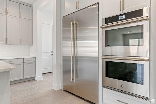 705 W Emerald Point Dr, St George, UT 84790 - kitchen featuring appliances with stainless steel finishes, light tile patterned floors, light countertops, and backsplash