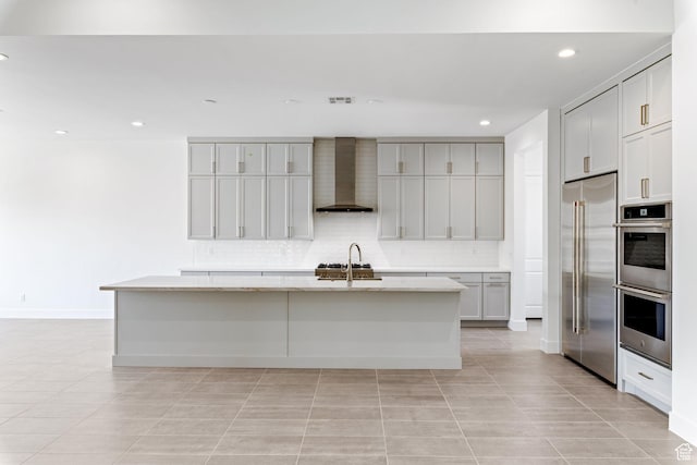 705 W Emerald Point Dr, St George, UT 84790 - kitchen featuring wall chimney exhaust hood, appliances with stainless steel finishes, light tile patterned flooring, a kitchen island with sink, and recessed lighting
