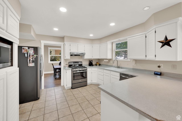 10132 S Kalinda Dr, Sandy, UT 84092 - kitchen featuring appliances with stainless steel finishes, under cabinet range hood, a sink, white cabinets, and light tile patterned floors