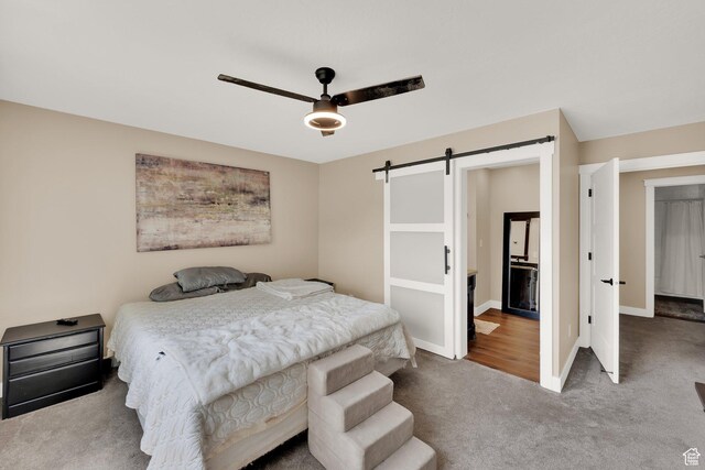 10132 S Kalinda Dr, Sandy, UT 84092 - bedroom with a barn door, carpet floors, baseboards, and a ceiling fan