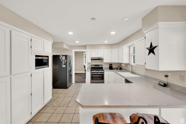 10132 S Kalinda Dr, Sandy, UT 84092 - kitchen with stainless steel appliances, under cabinet range hood, a sink, a peninsula, and light countertops