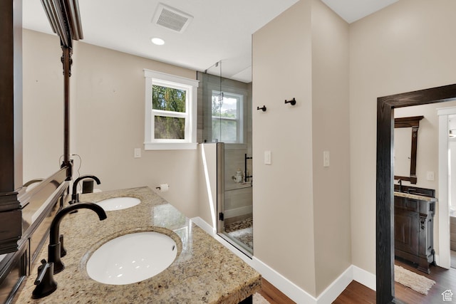 10132 S Kalinda Dr, Sandy, UT 84092 - bathroom featuring a stall shower, double vanity, wood finished floors, baseboards, and recessed lighting