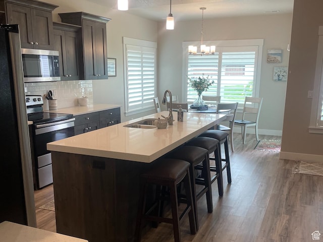 4422 W 2425 N, Plain City, UT 84404 - kitchen with stainless steel appliances, a sink, tasteful backsplash, wood finished floors, and a chandelier