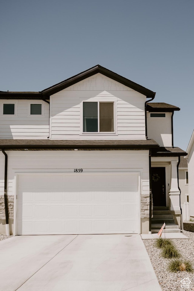 1859 N Blue Iris Ave Unit 1078, Tooele, UT 84074 - view of front of home with an attached garage, driveway, and stone siding