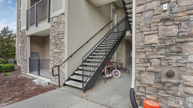 156 W Springview Dr Unit 505, Saratoga Springs, UT 84045 - view of exterior entry featuring stone siding, central AC unit, and stucco siding