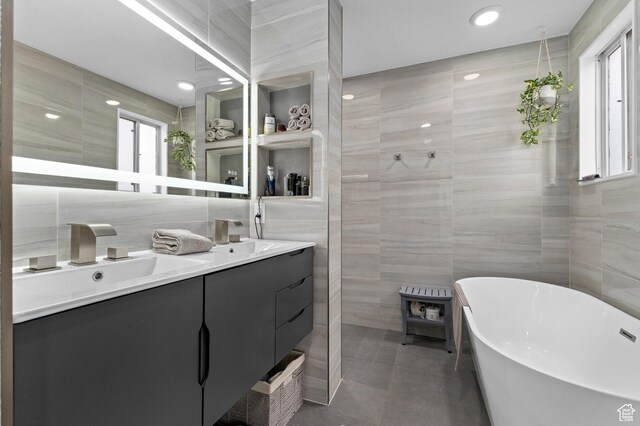 1616 E Waters Ln, Sandy, UT 84093 - bathroom with tile walls, a wood stove, double vanity, a freestanding tub, and tile patterned floors