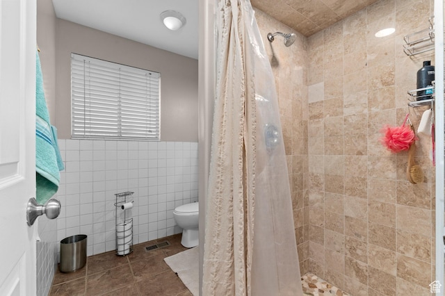 1616 E Waters Ln, Sandy, UT 84093 - bathroom featuring tile walls, toilet, a tile shower, and tile patterned flooring