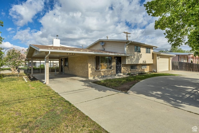 4480 S 4800 W, West Valley City, UT 84120 - split level home featuring concrete driveway, a carport, a chimney, brick siding, and an attached garage