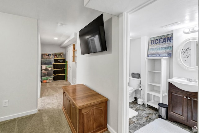 1038 N Plaza Dr, Richfield, UT 84701 - hallway featuring a sink, light carpet, and baseboards