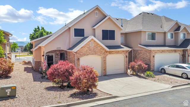 1038 N Plaza Dr, Richfield, UT 84701 - view of front facade featuring stucco siding, a garage, driveway, and stone siding
