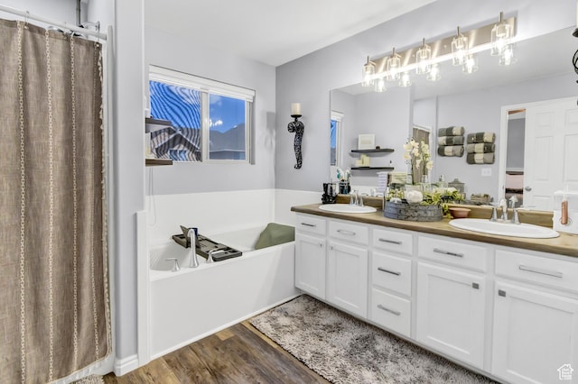 1038 N Plaza Dr, Richfield, UT 84701 - bathroom featuring double vanity, a garden tub, wood finished floors, and a shower with shower curtain