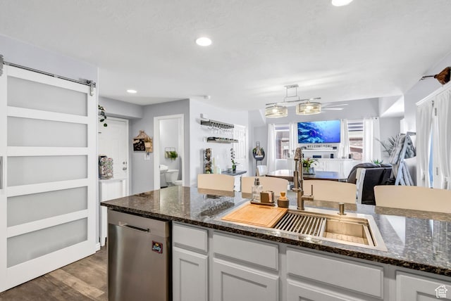 1038 N Plaza Dr, Richfield, UT 84701 - kitchen with a sink, dark wood-style flooring, dark stone counters, open floor plan, and white cabinetry