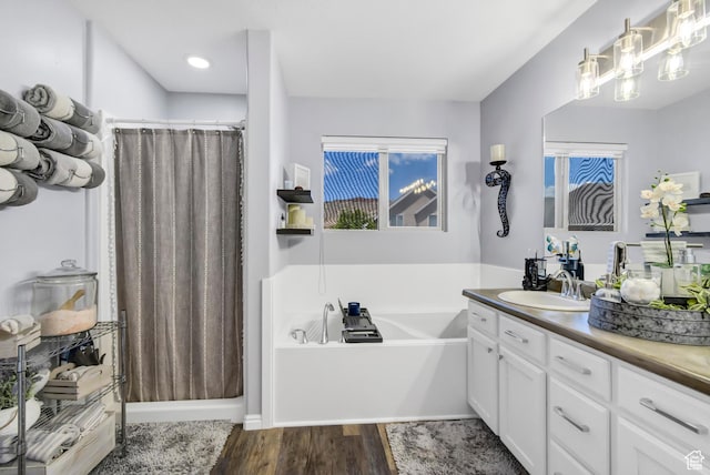 1038 N Plaza Dr, Richfield, UT 84701 - bathroom featuring vanity, a garden tub, wood finished floors, and a shower with curtain