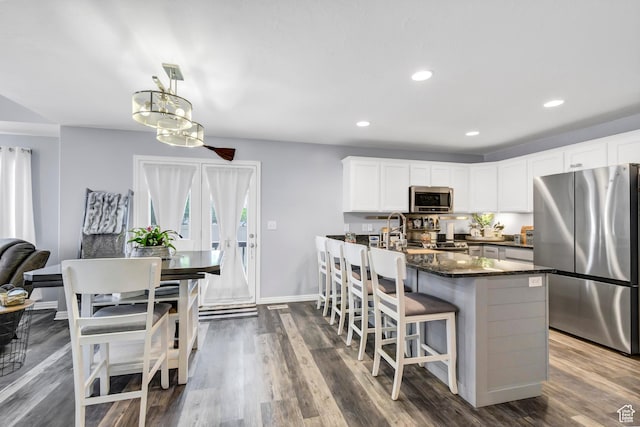 1038 N Plaza Dr, Richfield, UT 84701 - kitchen featuring stainless steel appliances, a kitchen breakfast bar, dark wood-style flooring, white cabinetry, and recessed lighting
