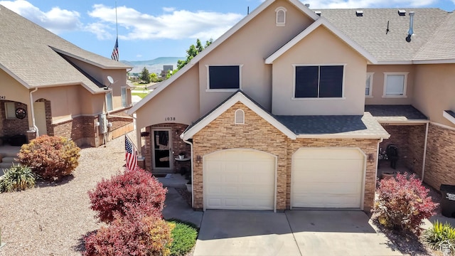 1038 N Plaza Dr, Richfield, UT 84701 - view of front of home with stucco siding, stone siding, concrete driveway, an attached garage, and a shingled roof