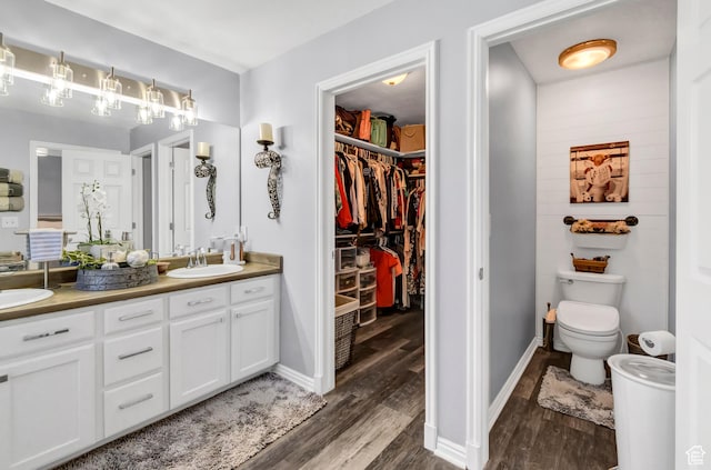 1038 N Plaza Dr, Richfield, UT 84701 - full bath featuring double vanity, wood finished floors, toilet, a walk in closet, and baseboards