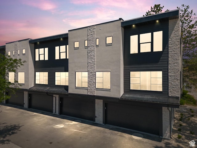 321 E 2100 S Unit 4, Salt Lake City, UT 84115 - view of front of house featuring an attached garage, stucco siding, driveway, a standing seam roof, and metal roof