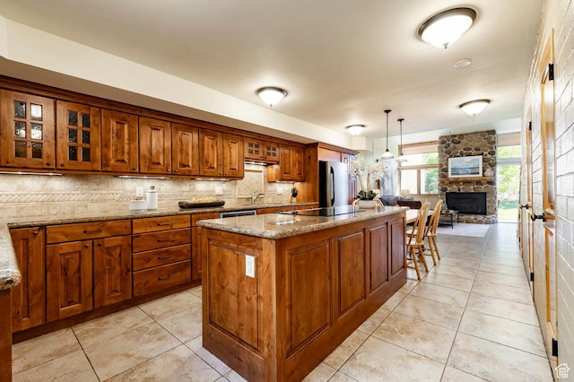 1672 Captain Molly Dr Unit 330, Park City, UT 84060 - kitchen with brown cabinetry, a sink, a kitchen island, decorative backsplash, and light stone counters
