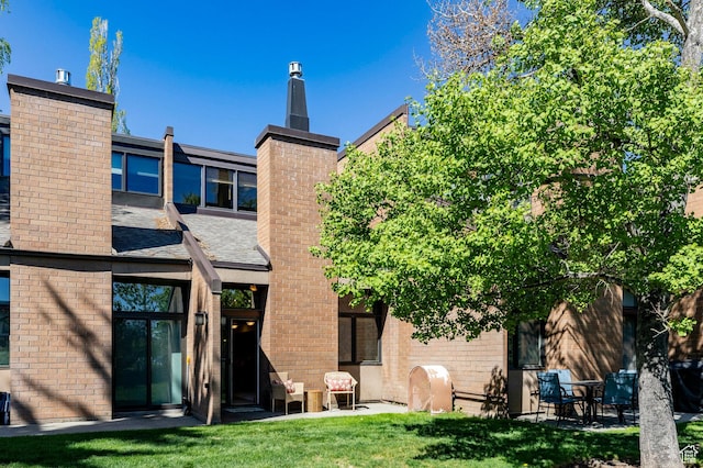 1672 Captain Molly Dr Unit 330, Park City, UT 84060 - rear view of house featuring a chimney, brick siding, a yard, and a shingled roof
