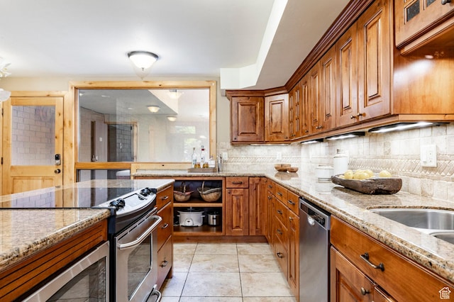 1672 Captain Molly Dr Unit 330, Park City, UT 84060 - kitchen featuring appliances with stainless steel finishes, brown cabinetry, and light stone counters