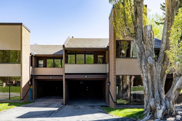 1672 Captain Molly Dr Unit 330, Park City, UT 84060 - view of front of home featuring a shingled roof, a garage, asphalt driveway, and stucco siding
