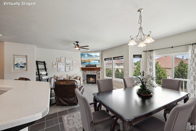 14499 S River Chase Rd, Herriman, UT 84096 - dining space with a warm lit fireplace, plenty of natural light, a ceiling fan, and a chandelier