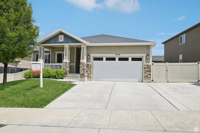 14499 S River Chase Rd, Herriman, UT 84096 - craftsman-style house featuring stone siding, a porch, a garage, driveway, and a gate
